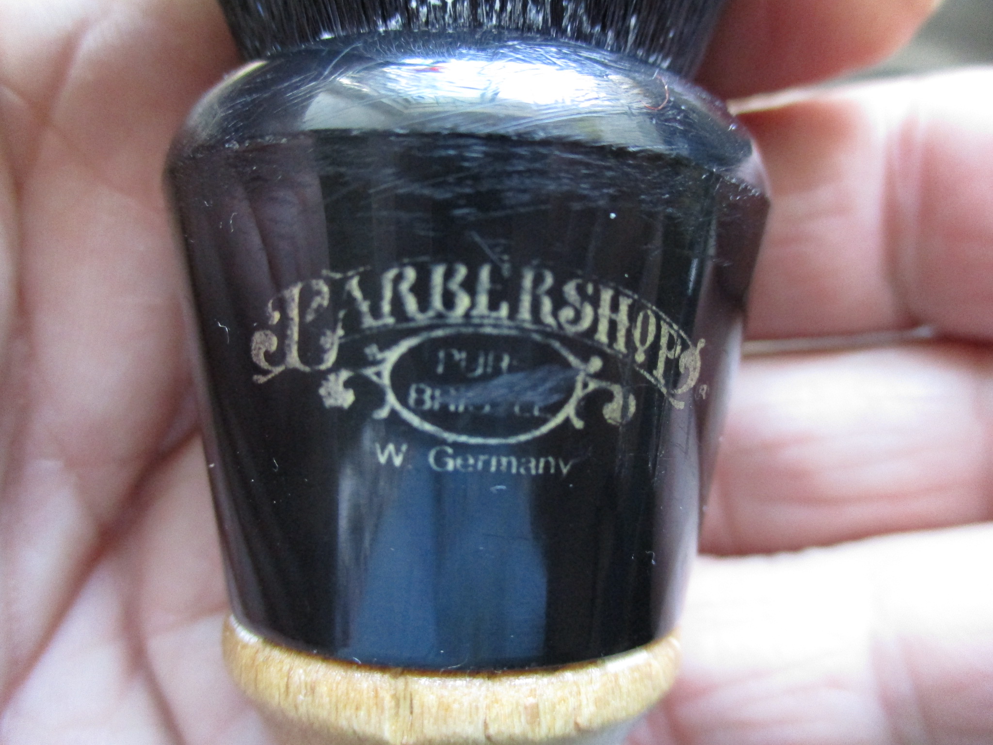 Closeup of handle of Barbershop brush, with APShaveCo Tuxedo knot.